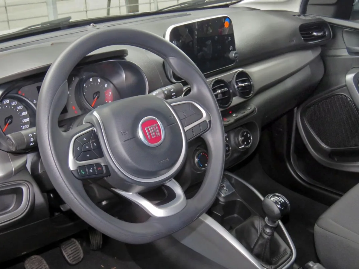 Interior de Fiat Argo com volante, painel, central multimídia e câmbio manual