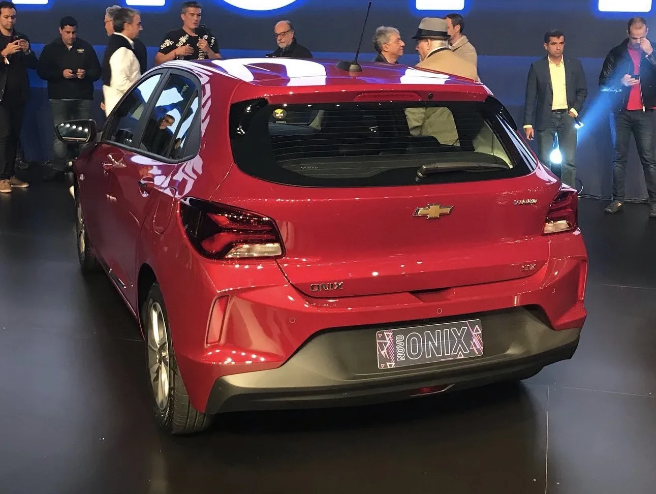 Chevrolet Onix vermelho da segunda geração visto pela traseira